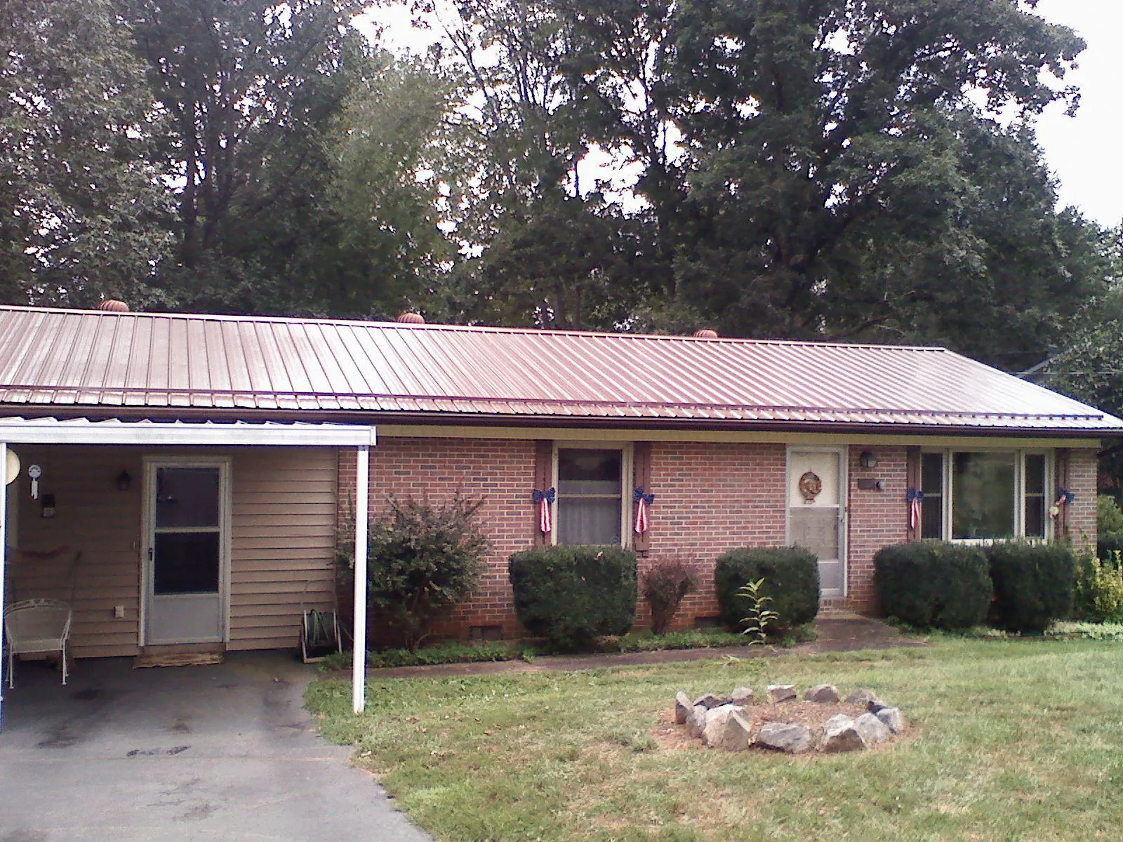 Bronze metal roof and carport on a brick ranch home — Roof Repair work by our crew in Ferguson